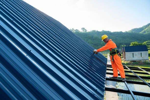 Construction worker in orange uniform working on a roof